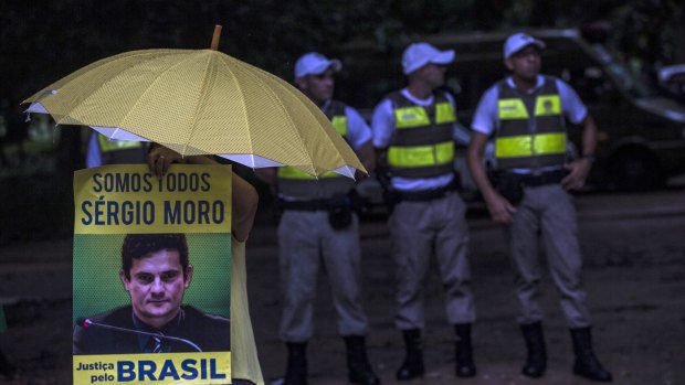 A demonstrator holds an umbrella and a sign that reads "We are all Sergio Moro, justice for Brazil," referring to Car wash lead judge Sergio Moro, in Porto Alegre on Wednesday.