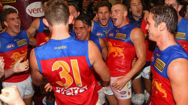 Harris Andrews, Allen Christensen, Mitch Robinson and Dayne Beams of the Lions sing the song in the rooms after winning their first match of 2015.