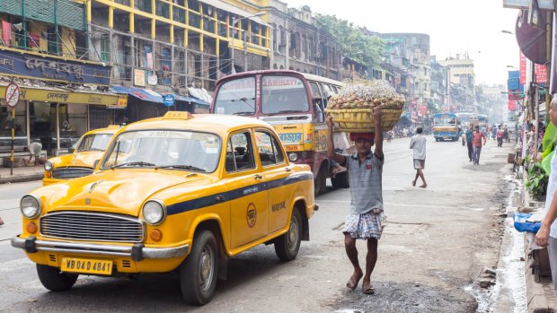 The ubiquitous yellow taxi in a Kolkata street.