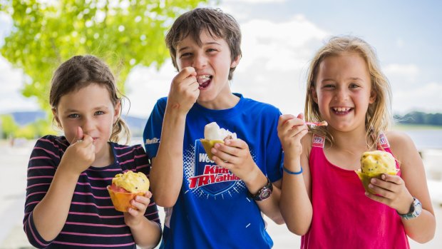 Alice, 7, Matthew, 10, and Laura, 9, of Canberra enjoy ice-cream by the lake to cool down on Sunday.