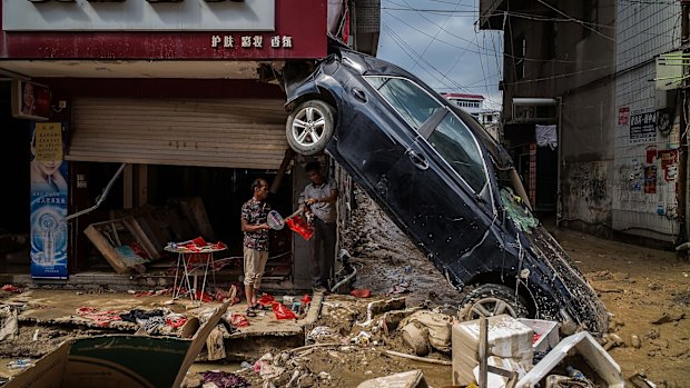 People stand at the damaged shopping street in the aftermath on July 12, 2016 in Fuijan, China. 