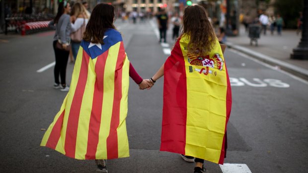 Irene Guszman, 15, wearing a Spanish flag on her shoulders and Mariona Esteve, 14, with an 'estelada' or independence flag, in Barcelona on October 3.