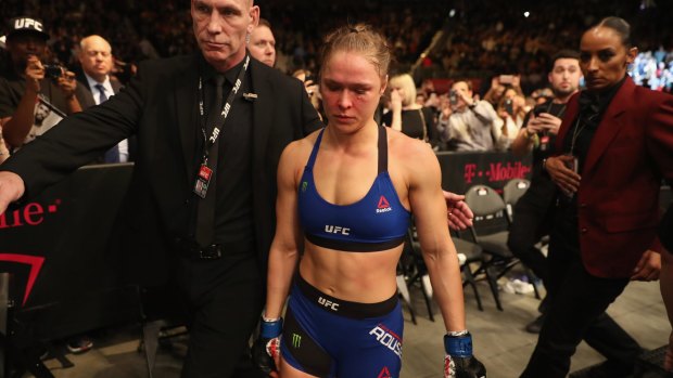 Bloodied and beaten: Ronda Rousey leaves the Octagon after her loss last weekend.