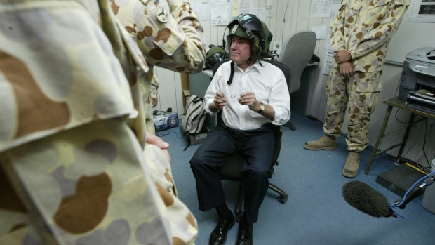 Then prime minister John Howard tries on a night vision helmet while preparing to enter Iraq for Anzac Day in 2004.