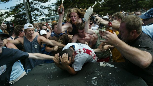 A mob surrounds and attacks a man of Middle Eastern appearance during the Cronulla riots.