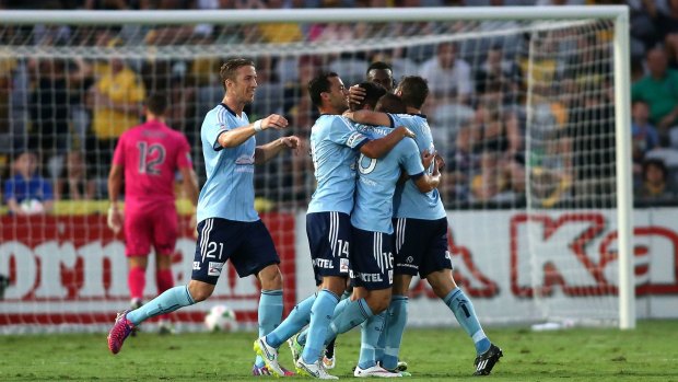 Dominant: Sydney FC players celebrate scoring against the Mariners on Saturday night.