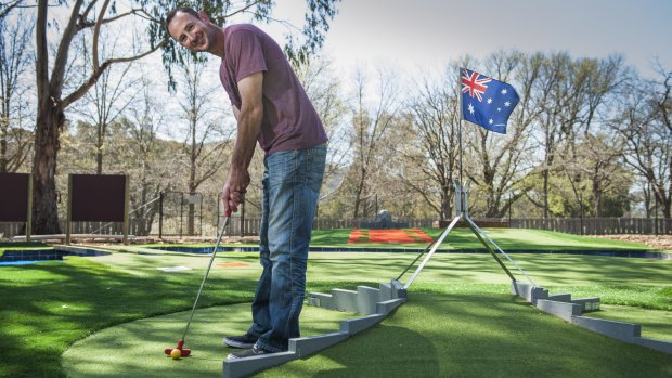 Owner of Yarralumla Play Station Jason Perkins teeing off at the Canberra-themed mini golf course.