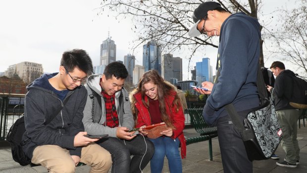 People play Pokemon Go on their phones at Southgate in Melbourne.