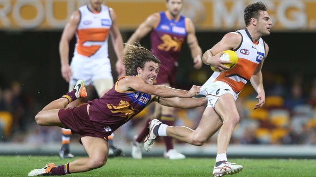 Sums it all up: Giant Stephen Conigliois is just beyond the reach of Brisbane's Rhys Mathieson on Sunday night at the Gabba.
