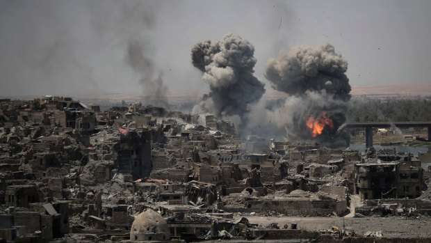 In this July 2017 photo, airstrikes target IS positions on the edge of the Old City, a day after Iraq's prime minister declared "total victory" in Mosul, Iraq.