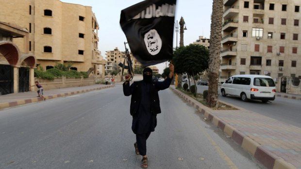 A member of Islamic State waves an IS flag in Raqqa, Syria.