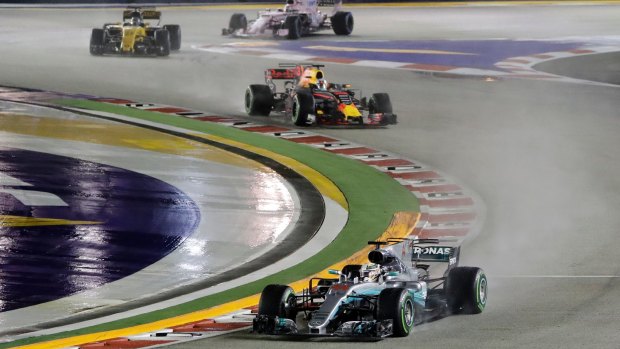 Mercedes' Lewis Hamilton leads Red Bull's Daniel Ricciardo in the rain in Singapore.