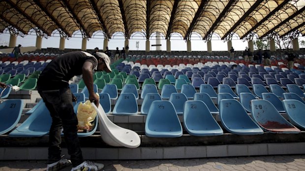 A worker repairs seats in an enclosure at the Gaddafi Stadium.