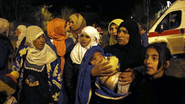 People wait to leave the besieged town of Madaya, north-west of Damascus. Aid convoys reached three besieged villages on Monday.