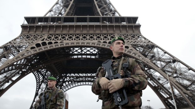 French soldiers patrol in front of the Eiffel Tower after terrorists killed at least 12 people at the Charlie Hebdo offices in Paris. 