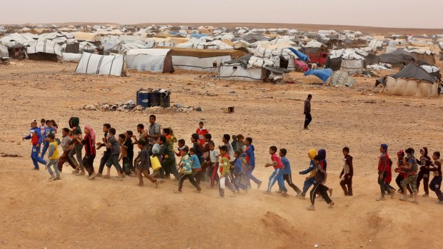 Syrian refugee boys await approval to enter Jordan. Jordan's Border Guard says the number of refugees amassed in remote desert areas on the border and waiting to enter has risen to a new high of 59,000.