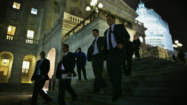 Members of the US House of Representatives leave the Capitol after the vote.