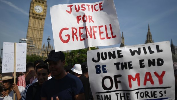 Protesters hold signs calling for a change of government and justice for the victims of the Grenfell Disaster in Parliament Square during an anti-government protest.