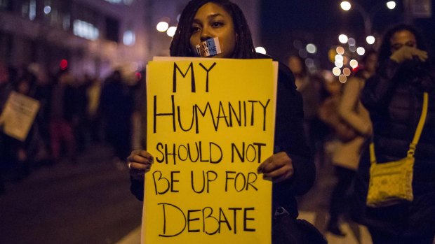 A female protester, demanding justice for Eric Garner, holds a placard in Brooklyn, New York.