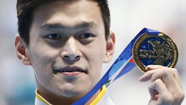 Accused of attacking female swimmer: Sun Yang displays his gold medal after winning the men's 800m freestyle final at the Aquatics World Championships in Kazan.