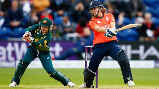 Player of the match, Natalie Sciver of England, cuts as Australian wicketkeeper Alyssa Healy looks on.