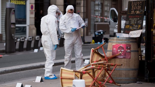 Police forensic experts work on the scene of one the shootings that took place in Paris at the Cafe Comptoir Voltaire.