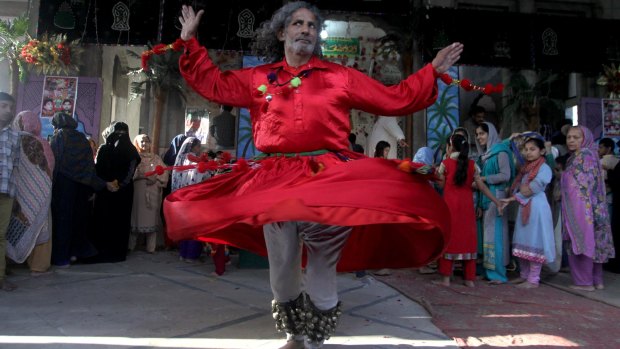 A Muslim devotee dances at the shrine of Shah Hussain, a poet also regarded as a Sufi saint, during a festival to celebrate him in Lahore on Saturday.
