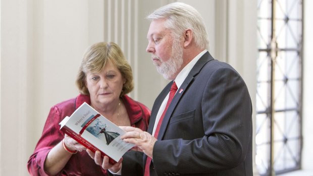 Daniel Morcombe's parents flip through a copy of their book which reveals their struggles over the past 10 years.