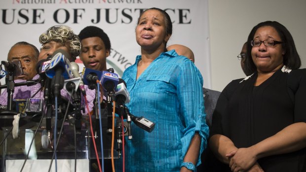 Eric Garner's wife Esaw, in blue, at a press conference hosted by the Reverend Al Sharpton's National Action Network in New York after the decision.