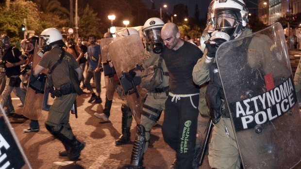 A protester is arrested by riot police in Athens on Wednesday. 