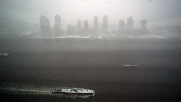 White-out: A tugboat sails by the city on the East River.