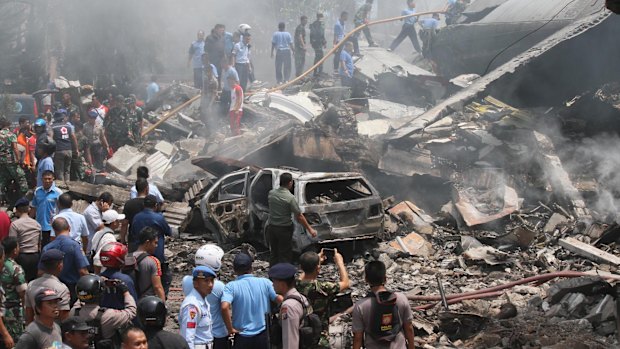 Firefighters and military personnel inspect the site where an Air Force cargo plane crashed.