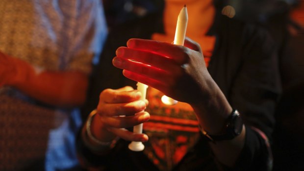 Bangladeshis light candles as they pay tribute to those killed in the attack at the Holey Artisan Bakery in Dhaka.