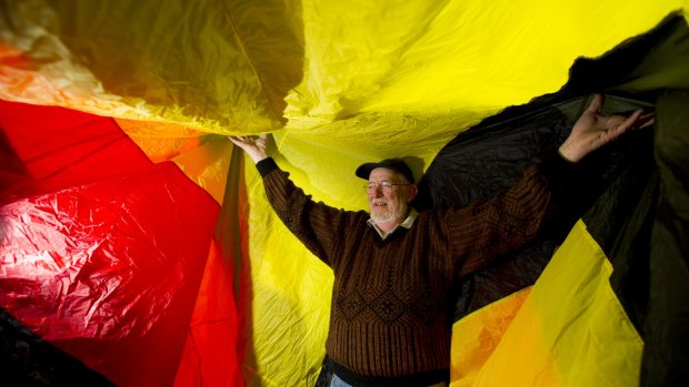 Ian Burrell stands inside the caterpillar kite that will be flying over Googong.