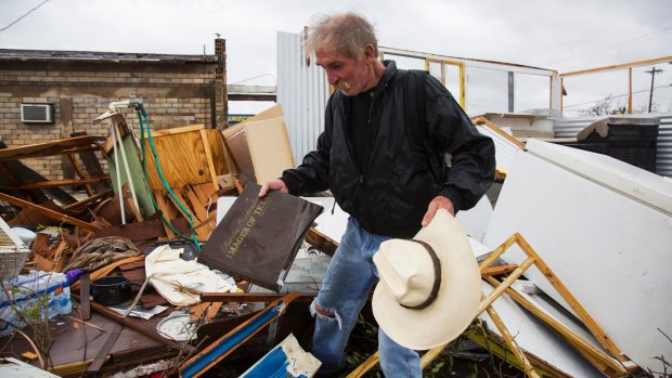 Harold Nubles searches through what is left of his barbecue truck in Refugio, Texas.