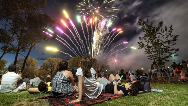 Families watch the fireworks in Melbourne on New Year's Eve. 