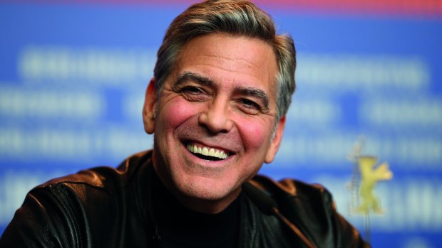 George Clooney turns on his famous smile at the Berlin Film Festival.