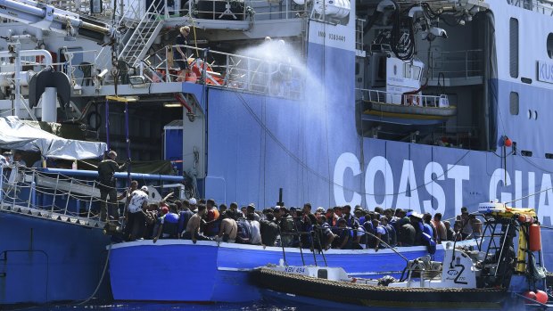 Some of the 441 refugees attempting to cross from Libya to Europe on a wooden boat are rescued by the Swedish Coast Guard off Libya. 