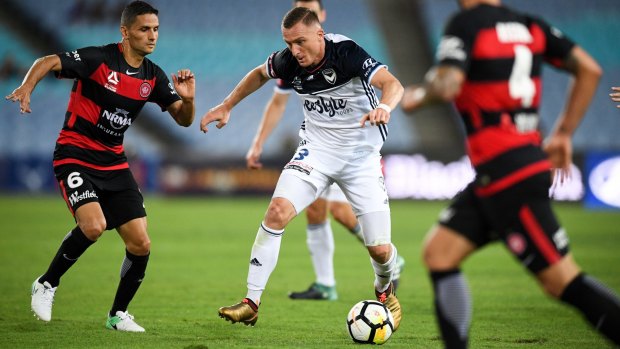 On song: Besart Berisha (centre) of the Victory competes for possession against Marcelo Carrusca of the Wanderers.