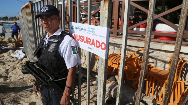 Police guard the exit of the Blue Parrot nightclub in Playa del Carmen, hours after several people were shot. 