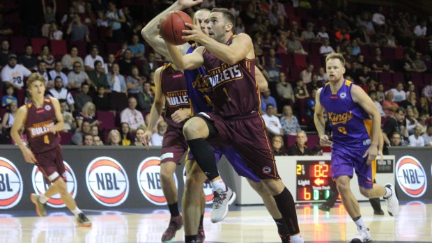 Brisbane guard Adam Gibson glides to the basket past Sydney Kings centre Aleks Maric on Saturday night.