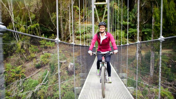 Megan Gale crosses the Maramataha Suspension Bridge on The Timber Trail in New Zealand, beckoning Australians to join her.