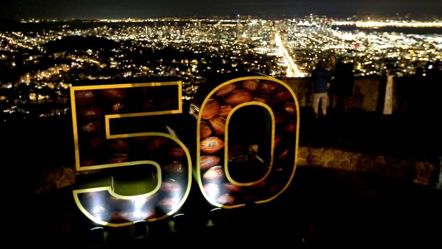 A Super Bowl 50 sign stands in a park overlooking San Francisco.