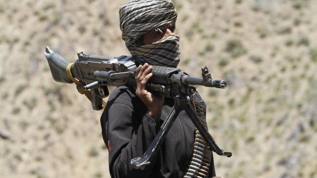 A member of a breakaway faction of the Taliban fighters guards a gathering in Shindand district of Herat province, Afghanistan. 