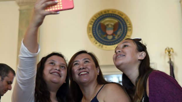 Tourists take a group photo outside the Blue Room while touring the White House in Washington.