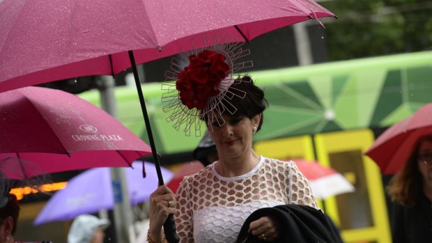 Racegoers were drenched while making their way to Oaks Day at Flemington. 