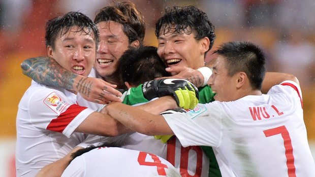 Super sub: Sun Ke is mobbed by teammates after scoring the winner for China against Uzbekistan in Brisbane.
