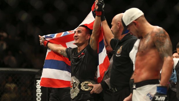 Belt up: Hawaiian Max Holloway celebrates his title win over America's Anthony Pettis.