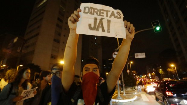 A man holds a sign that reads "Elections now" during a protest against President Michel Temer in Sao Paulo.