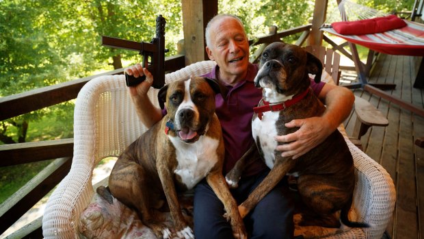 Richard Feldman at his home in Rindge, New Hampshire with his dogs Stanley and Stella and a version of the TEC-9.